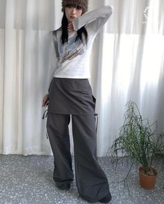 Woman in a fur hat and wide leg pants posing indoors