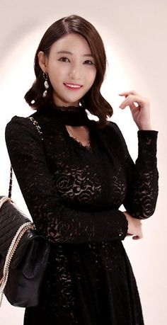 Woman in a black lace dress with a choker and quilted bag