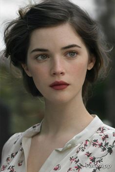 Woman with green eyes and dark hair wearing a floral shirt
