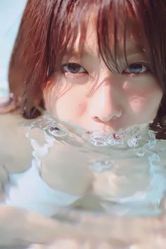 Woman with wet brown hair and cleavage visible in water with bubbles
