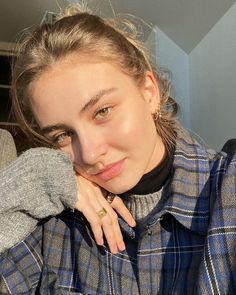 Woman in a plaid shirt with a messy bun, illuminated by golden hour light