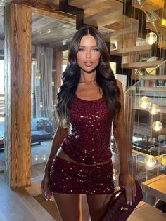 Woman in a sequin top and mini skirt posing indoors