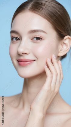 Woman with brown hair and bare shoulders touching her cheek