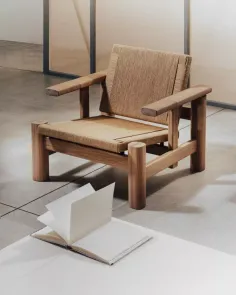 A wooden chair with a woven seat next to an open book on a white surface
