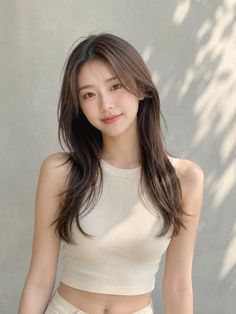 Woman with long brown hair wearing a crop top outdoors with soft lighting