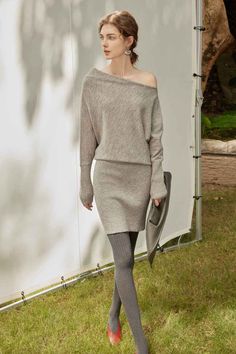 Woman in a gray knitted dress and tights walking outdoors