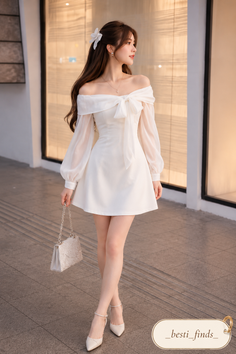 Woman in a white off-shoulder dress and high heels holding a sparkling handbag