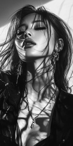 Woman with long hair and jewelry in a dramatic black and white portrait