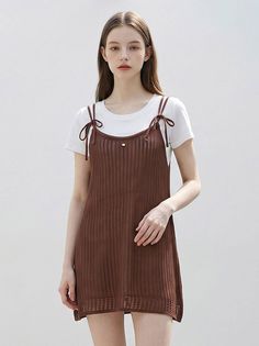 Woman in a brown knit dress over a white t-shirt against a plain background