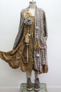 Mannequin wearing a layered outfit with a plaid jacket and brown dress
