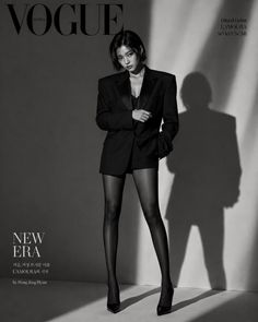 Woman in a suit jacket, shorts, and tights posing for a Vogue cover