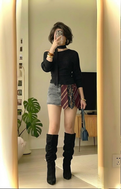 Woman in an off-shoulder top, mini skirt, and knee-high boots taking a mirror selfie