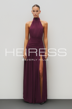 Woman in a maroon halter neck dress with a high slit and ruched waist