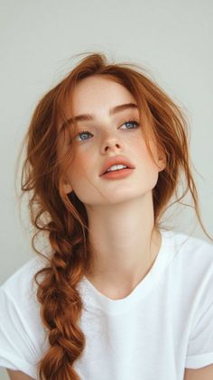 Woman with red braided hair and freckles looking up