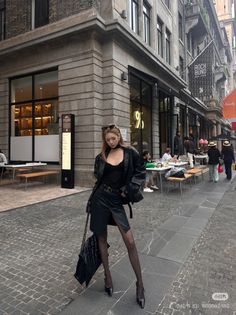 Woman in a black leather jacket and mini skirt on a city street