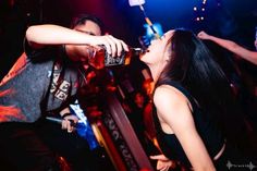 People drinking alcohol at a nightclub with neon lighting