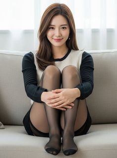 Woman in a black and white sweater and black pantyhose sitting on a couch