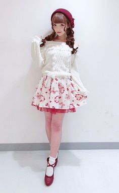 Woman with pigtails and a beret wearing an off-shoulder sweater and mini skirt