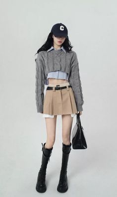 Woman in a cropped sweater, mini skirt, and knee-high boots with a baseball cap