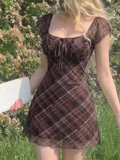 Woman in a brown plaid dress with blonde hair outdoors
