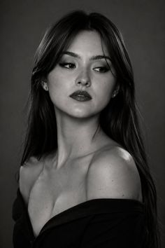 Woman with long dark hair and an off-shoulder top in a black and white portrait