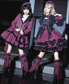 Two women in matching pink plaid gothic outfits and berets at night