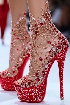 Pair of red high heels with intricate rhinestone and jewel embellishments