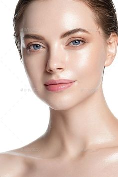 Woman with blue eyes and pink lips, wet hair, and glowing skin on a white background