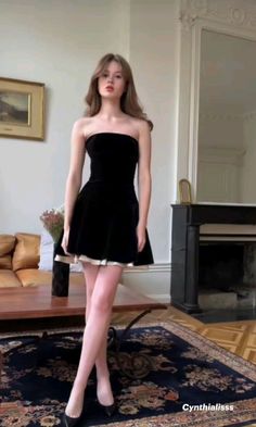 Woman in a black strapless dress posing indoors