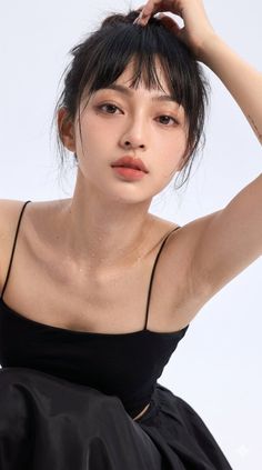 Woman with wet skin and black hair in a black top, looking at the camera