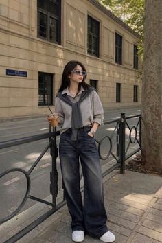 Woman in a striped shirt and wide leg jeans on a city street
