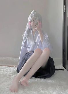 Person with white hair and pink ribbons wearing a kimono, sitting on a white rug
