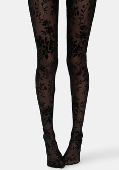 Legs wearing black sheer tights with a floral pattern against a white background