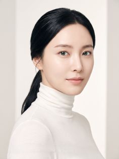 Woman with black hair in a ponytail wearing a white turtleneck