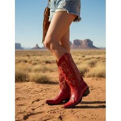 Person in red cowboy boots and denim shorts in a desert landscape