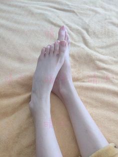 Bare feet and lower legs on a light brown blanket