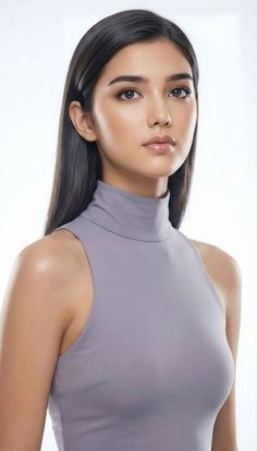 Woman with long dark hair wearing a grey turtleneck top, studio portrait