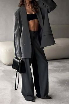 Woman in an oversized blazer and wide-leg pants with a black crop top