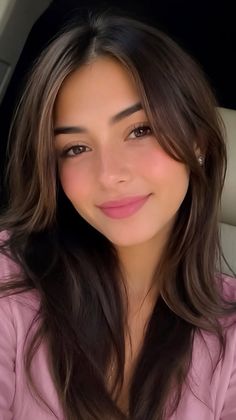 Woman with long brown hair and pink lipstick wearing a pink top