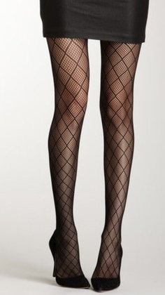 Person wearing fishnet stockings, a black skirt, and high heels in a studio