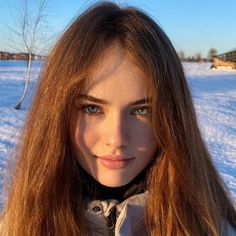 Woman with long hair in a snowy field during golden hour
