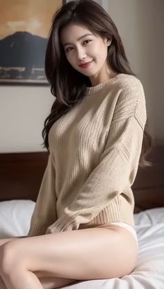 Woman in a beige sweater and white underwear sitting on a bed