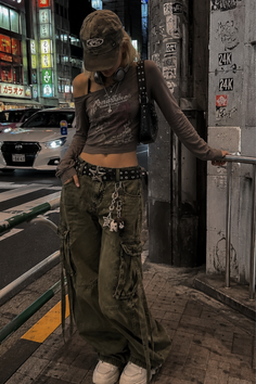 Person in cargo pants and a crop top on a city street at night
