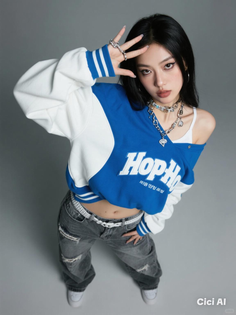 Woman in a blue and white jacket and ripped jeans posing in a studio