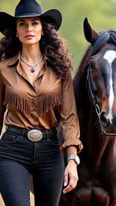 Woman in a cowboy hat and fringe shirt standing next to a horse