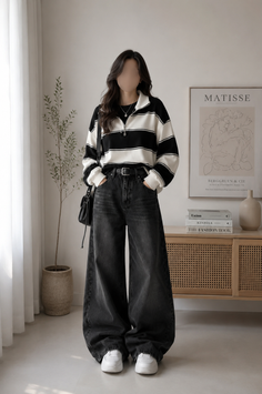 Woman in a striped shirt and wide leg jeans standing in a minimalist room