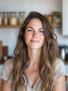 Woman with long brown hair smiling in an indoor setting