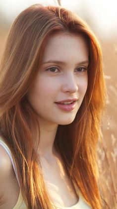 Woman with long red hair in a sunlit outdoor setting