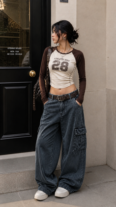 Woman in a crop top and baggy jeans standing outdoors