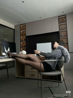 Woman in black tights and silver heels with her feet on a desk in an office